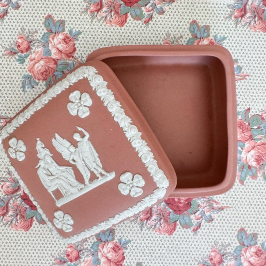 Decorative terracotta Wedgwood dish with floral and classical design on a floral patterned background